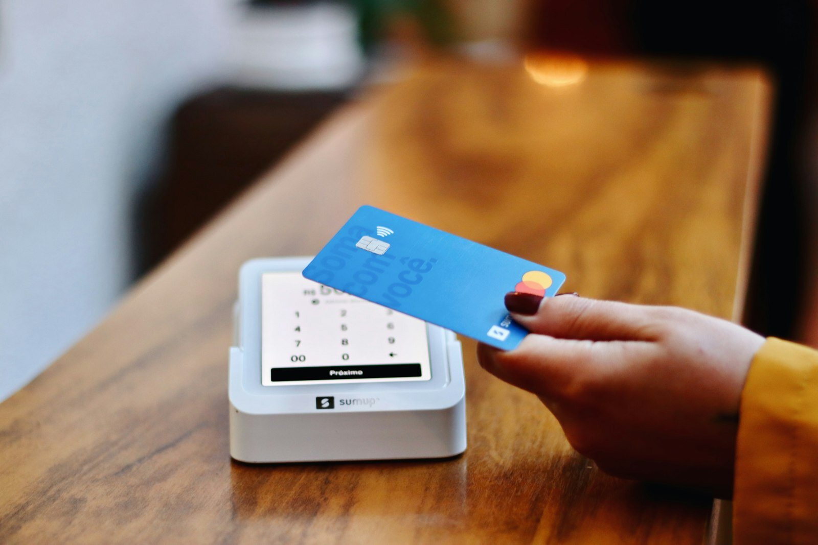 Customer tapping a card on a contactless payment terminal to leave a digital tip