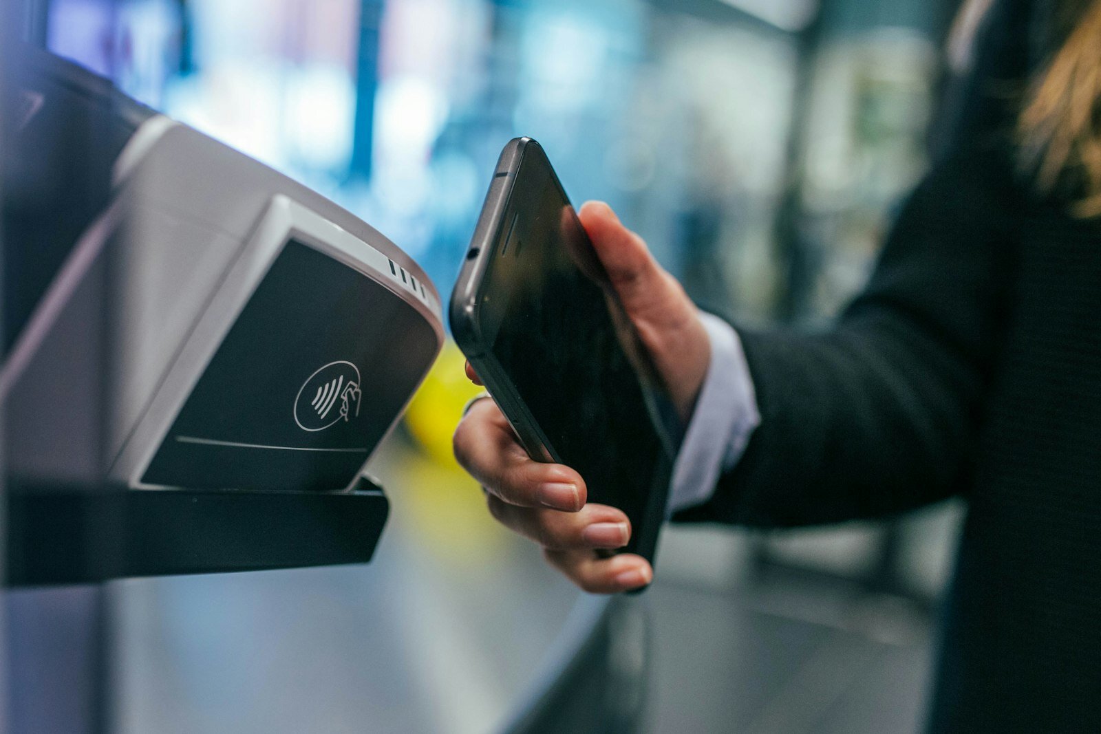 A hospitality worker handing a card payment terminal to a customer at a restaurant table
